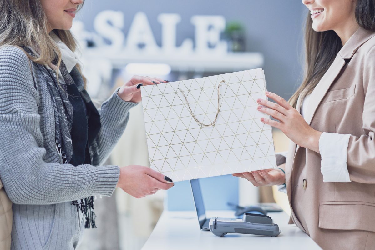 Woman seller and buyer in clothes store